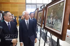 Khamphan Pheuiyavong, Politburo member and Head of the Lao Party Central Committee’s Propaganda and Training Commission, and delegates visit the exhibition. (Photo: VNA) 