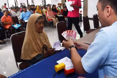A social worker hands cash assistance to an elderly beneficiary of the Family Hope Programme (PKH) in Madiun City, East Java, on March 14, 2025. (Photo: ANTARA)