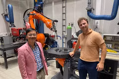 Assoc. Prof. Vu Viet Hung (left) visits a 3D-printed space made by robots. (Photo: VNA published) 