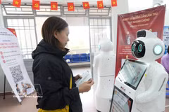 A citizen interacts with an AI-powered robot for guidance on administrative procedures at the Public Administration Service Centre of Xuan Huong–Da Lat ward, Lam Dong province. (Photo: VNA) 