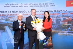 Ha Thanh (right), Chairwoman of the Ho Chi Minh City Union of Friendship Organsations, and Bui Quang Hai (left), Chairman of the Ho Chi Minh City Vietnam–Slovakia Friendship Association, present flowers to Marian Veres, Chargé d’Affaires ad interim of the Embassy of Slovakia in Vietnam at the ceremony on August 27. (Photo: VNA) 