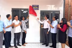 Secretary of the Bu Dang district Party Committee and Head of the Steering Committee for Eliminating Dilapidated Housing, Vu Luong (fourth from right), performs the ribbon-cutting ceremony to hand over a new house to a disadvantaged household. (Photo: VNA) 