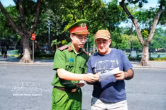 A police officer introduces a foreign visitor to the “Smart police station” kiosk, making it easier for international visitors to access police support services. (Photo: VNA) 
