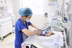 A medical worker cares for a newborn baby. (Photo published by VNA)