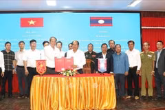 Deputy head of the Chu Lai Open Economic Zone management board Thieu Viet Dung and Director of the Sekong provincial Department of Finance Khamhou Onmani exchange the signed minutes of the meeting on May 6. (Photo: VNA) 