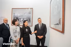 VNA General Director Vu Viet Trang, Thai Ambassador to Vietnam Urawadee Sriphiromya and others tour the exhibition. (Photo: VietnamPlus)