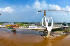 After about three years of construction, the new Duong Bridge in Phu Dong commune, Hanoi, is entering a decisive stage, with the main span over the river nearing completion. Approach roads and interchanges are also being accelerated, with the project expected to open to traffic in September 2026. (Photo: VietnamPlus)