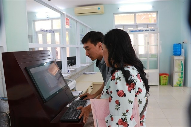 An official in Khanh Vinh commune, Khanh Hoa province, guides a woman to use the National Public Service Portal. Photo: VNA)