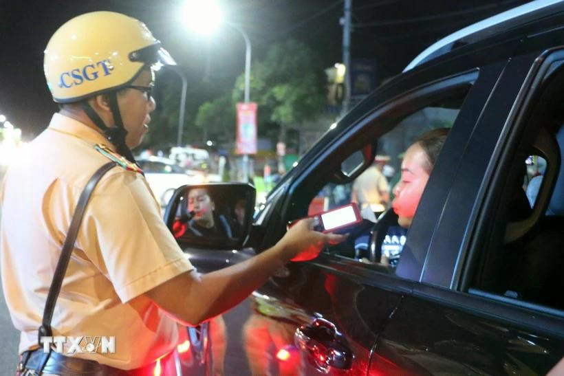 A police officer in Long Xuyen city conducts random breathalyser tests on a motorist. (Photo: VNA)