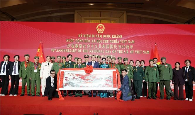 Delegates pose for a photo with a group of Chinese veterans who supported Vietnam during the war at the event (Photo: VNA)