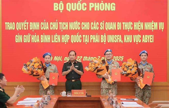 Senior Lieutenant General Phung Si Tan (second from left), Deputy Chief of the General Staff, presents decisions of the State President and the Minister of National Defence to three officers who are about to depart for duties at the UN peacekeeping mission in Abyei. (Photo: VNA)