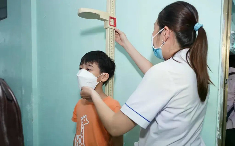 A health worker measures a boy's height as part of a screening programme to promptly detect children with malnutrition problems. (Photo: vtv.vn)