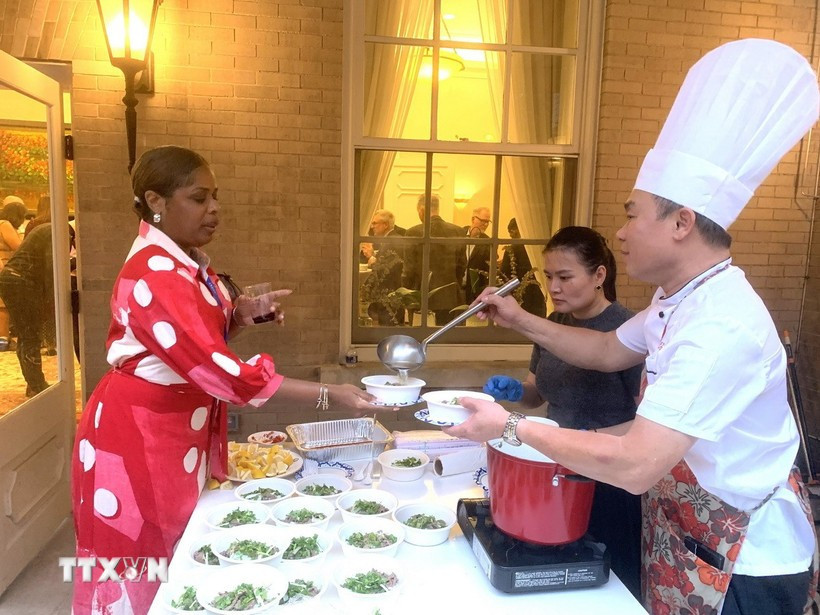 People enjoy beef "pho" - a traditional dish seasoned with typical Vietnamese spices at the event. (Photo: VNA)