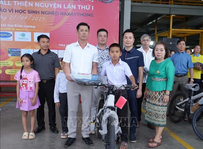 The head of the Nghe An entrepreneurs’ club in Naxaithong presents the gifts to a disadvantaged students at the ceremony. (Photo: VNA) 