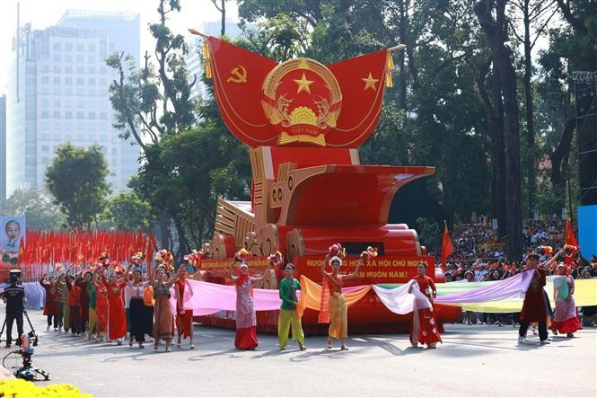 The vehicle carries the model of the National Emblem of the Socialist Republic of Vietnam in the parade. (Photo: VNA)