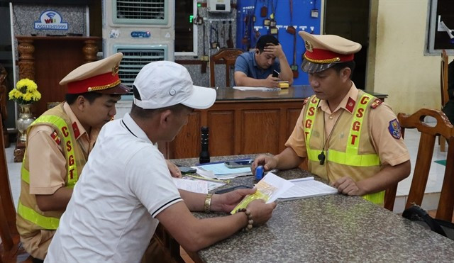 Traffic police in Dong Nai province handle a violation on National Route 14. (Photo: VNA)