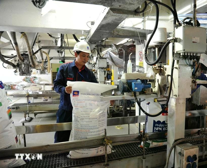 A worker operates modern automated lines to package nitrogen fertiliser. (Photo: VNA)
