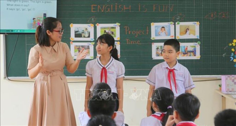 A teacher guides students to participate in a game in English. (Photo: VNA)
