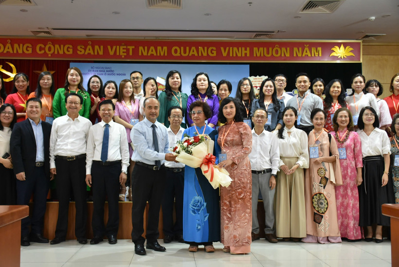Chairman of the State Committee for Overseas Vietnamese (L) presents flowers to representatives of Vietnamese language teachers abroad. (Photo: VNA)