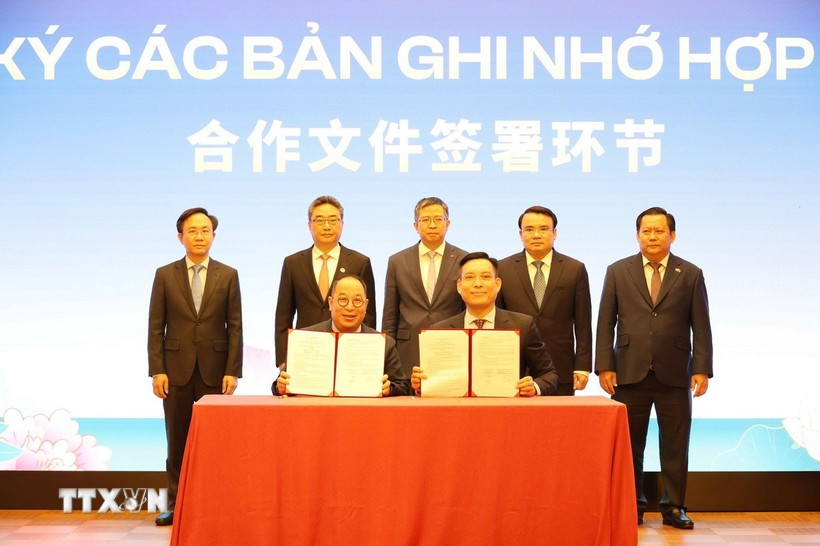 Representatives of Vietnamese and Chinese businesses sign a cooperation agreement at the forum. (Photo: VNA)