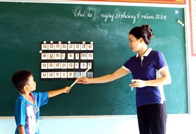 A teacher and a student in class at Thuong Hoa Primary and Secondary School in Minh Hoa district, located in the central coastal province of Quang Binh. (Photo: VNA)