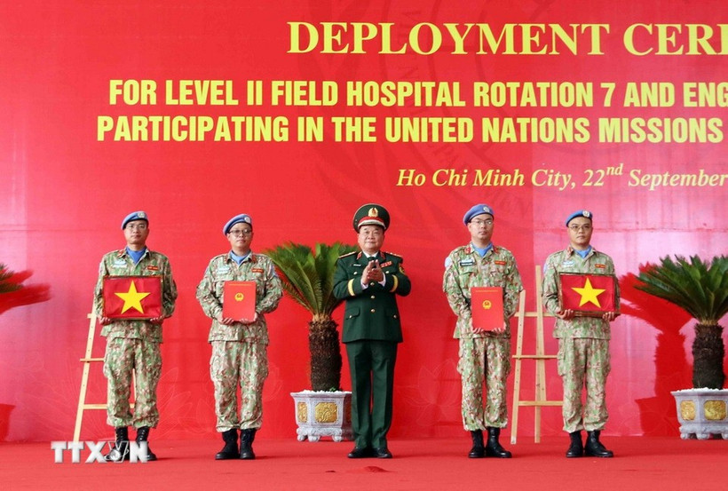 On behalf of the State President, Deputy Minister of National Defence Senior Lieutenant General Hoang Xuan Chien Hoang Xuan Chien presents the decision to Vietnamese units assigned to UN peacekeeping missions and hands over the national flag to them. (Photo: VNA)