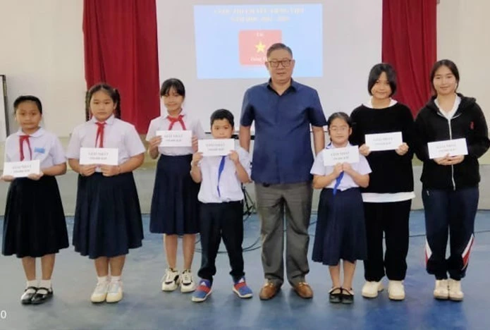 A representative from the organising board presents gifts to winning students (Photo: VNA)