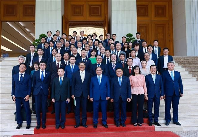 Prime Minister Pham Minh Chinh (centre, front) poses for a photo with Vietnamese officials and representatives of Japanese enterprises on August 12. (Photo: VNA)