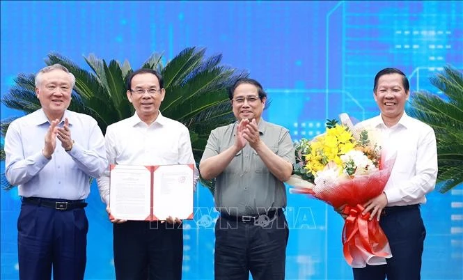 PM Pham Minh Chinh (second from right) presents the Decision approving HCM City's master planning scheme to its leaders. (Photo: VNA)