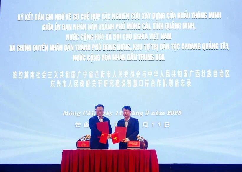 Chairman of the Mong Cai City People's Committee Ho Quang Huy, and Mayor of the Dongxing City People's Government Li Jian exchange cooperation agreement. (Photo: VNA)