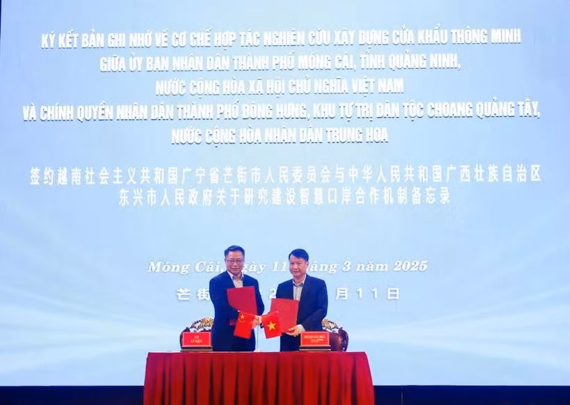 Chairman of the Mong Cai City People's Committee Ho Quang Huy, and Mayor of the Dongxing City People's Government Li Jian exchange cooperation agreement. (Photo: VNA)