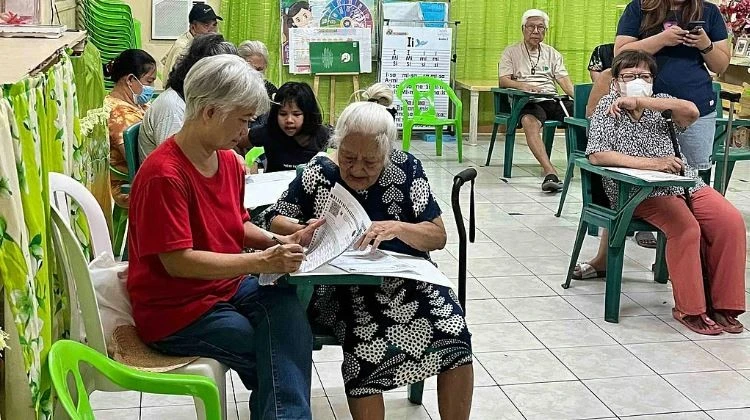 Senior citizens in Paltok Elementary School in Quezon City cast their votes, with the help of their relatives on May 12. (Photo: tribune.net.ph)