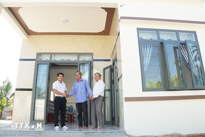 A revolution contributor is happy to get a new home built under the housing support programme. (Photo: VNA)