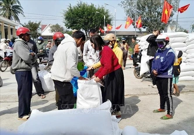 People in difficult circumstances receive rice aid on the occasion of the Lunar New Year Festival in Lak district, Dak Lak province. (Photo: VNA)