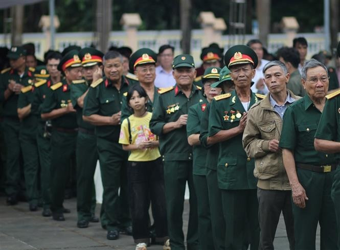 Veterans offer incense in memory of their fallen comrades at Duc Co Martyrs’ Cemetery. (Photo: VNA)