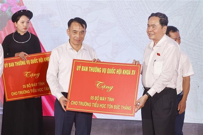 National Assembly Chairman Tran Thanh Man (R) presents 15 computer sets to Ton Duc Thang, Tan Trao, and Kim Quan Primary Schools in Tan Trao commune. (Photo: VNA)