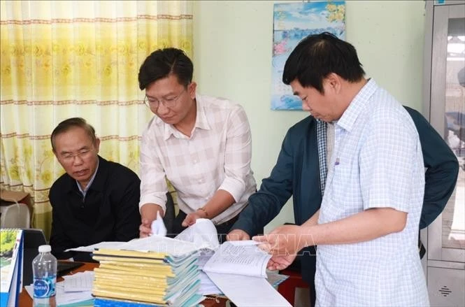 Deputy Minister of Agriculture and Rural Development Phung Duc Tien (first, left) and inspectors examine fishing vessels' daily records at Dong Tac fishing port in Tuy Hoa city, Phu Yen province. (Photo: VNA)