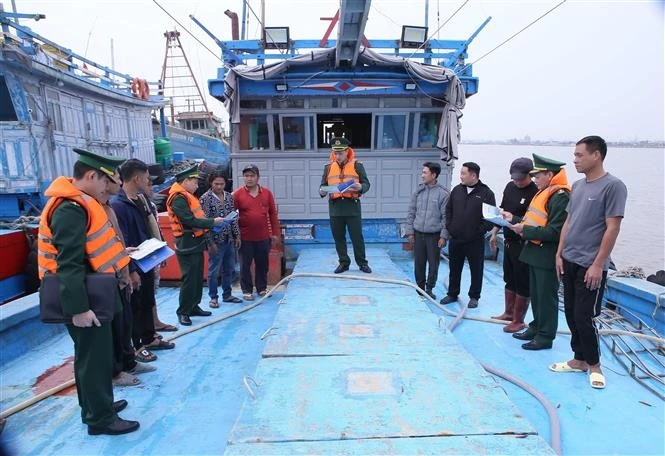 Officers and soldiers of Hai Thinh Port's Border Guard Post disseminate legal regulations for fishing at sea to fishermen. (Photo: VNA) 