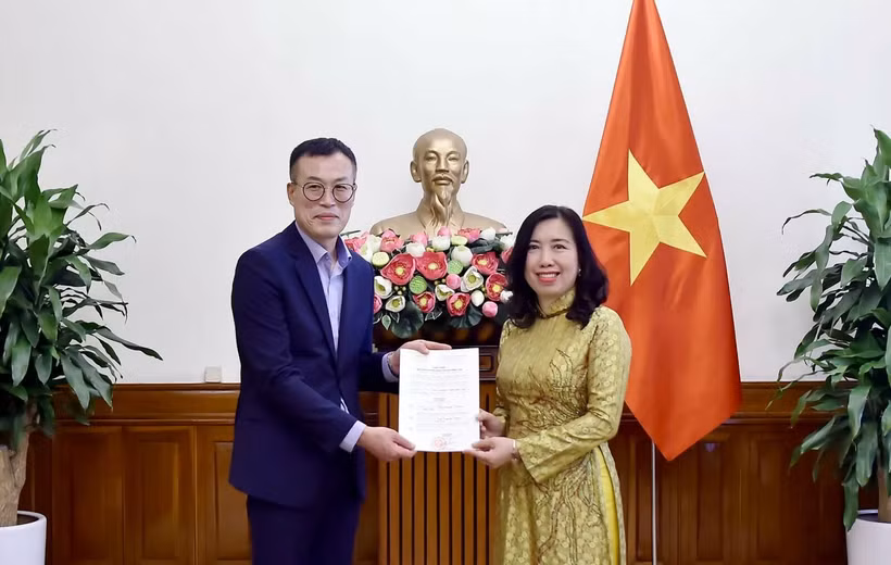 Deputy Minister of Foreign Affairs Le Thi Thu Hang (right) presents the licence to Chief representative of Financial News in Vietnam Kim Kwan Woong. (Photo: MoFA)