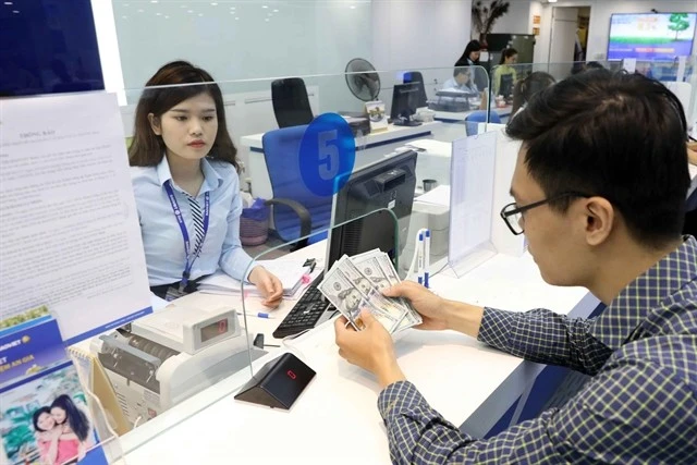 A customer conducts a transaction at an office of a bank in Hanoi (Photo: VNA)