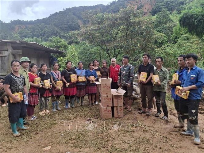 A representative of the Dien Bien Red Cross Society presents relief supplies to local residents. (Photo: VNA)