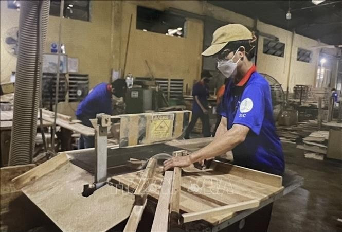 Workers at the Thuan An wood processing factory in Binh Duong province manufacture parts of tables and chairs. (Photo: VNA)