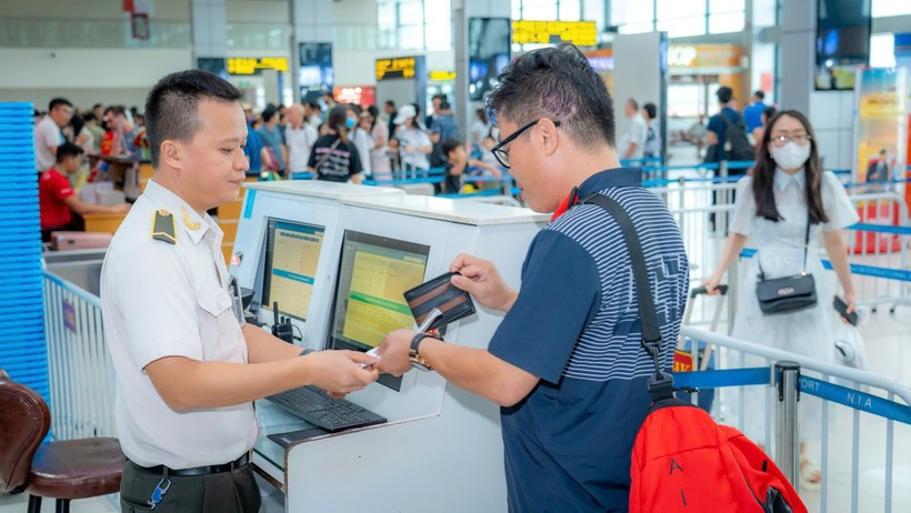Aviation security personnel checks passenger' documents before he boards the plane. (Photo: VietnamPlus)