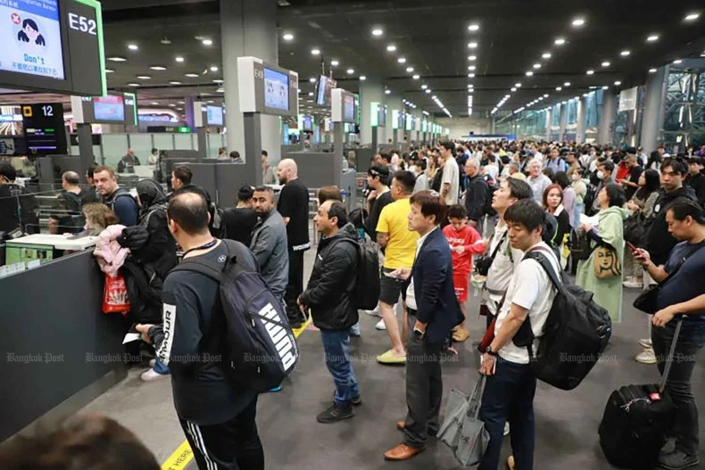 Foreign arrivals wait to go through the immigration process at Suvarnabhumi airport. (Bangkok Post file photo)