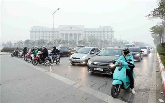 People comply with traffic signals at an intersection in Hanoi. (Photo: VNA)