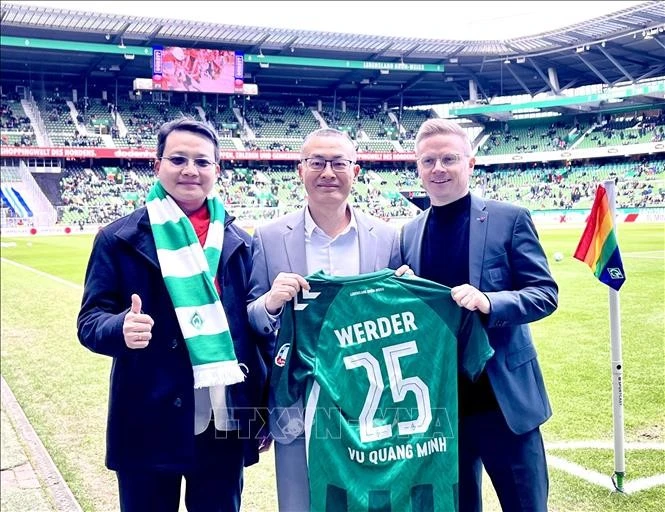 Vietnamese Ambassador to Germany Vu Quang Minh (C) presented with a jersey from Werder Bremen club (Photo: VNA)