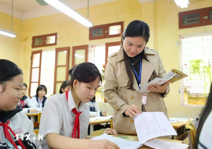 A teacher guiding her students in revision ahead of an examination. (Photo: VNA)