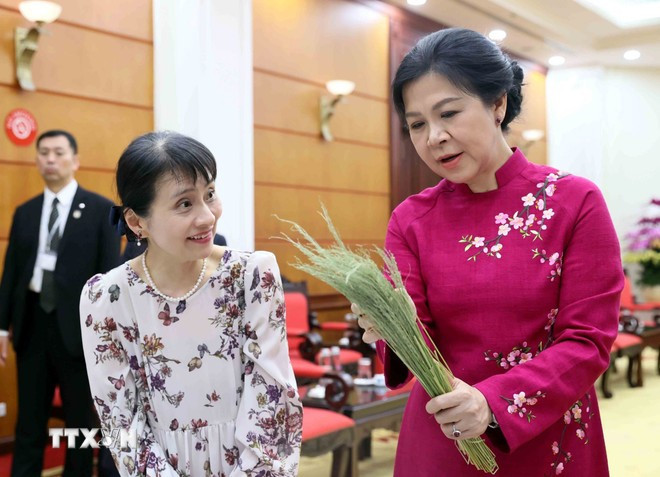 The spouse of Party General Secretary To Lam, Ngo Phuong Ly (R), introduces the spouse of visiting Japanese Prime Minister Ishiba Shigeru, Ishiba Yoshikoand, to the art of making Hanoi’s famed 'banh com'. (Photo: VNA)