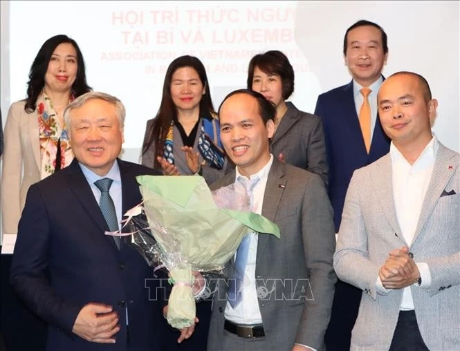 Permanent Deputy Prime Minister Nguyen Hoa Binh (first, left, front) presents flowers to ViLaB leader (Photo: VNA)