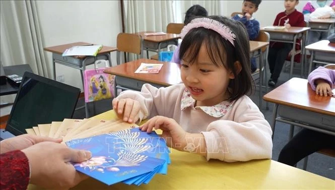 Mai Chi, a 5-year old student of the Dai Viet Language School, excited to receive lucky money, a tradition of Vietnamese people in Lunar New Year (Photo: VNA)